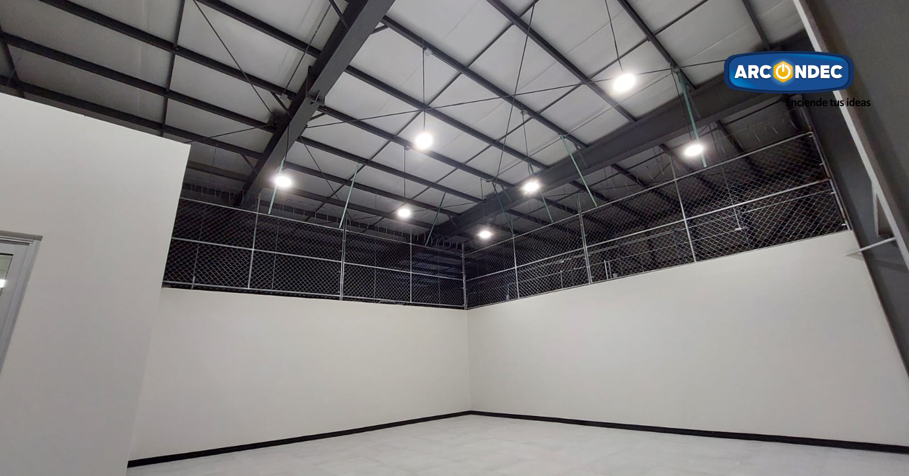 Área interior con estructura metálica, malla de seguridad perimetral y sistema de iluminación industrial, proyecto Arcondec SLRC